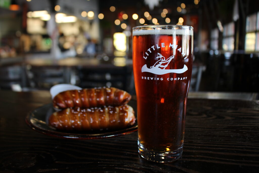 German Lager ABV 6.5 IBU 30 A glass of German Lager with some food in a plate.