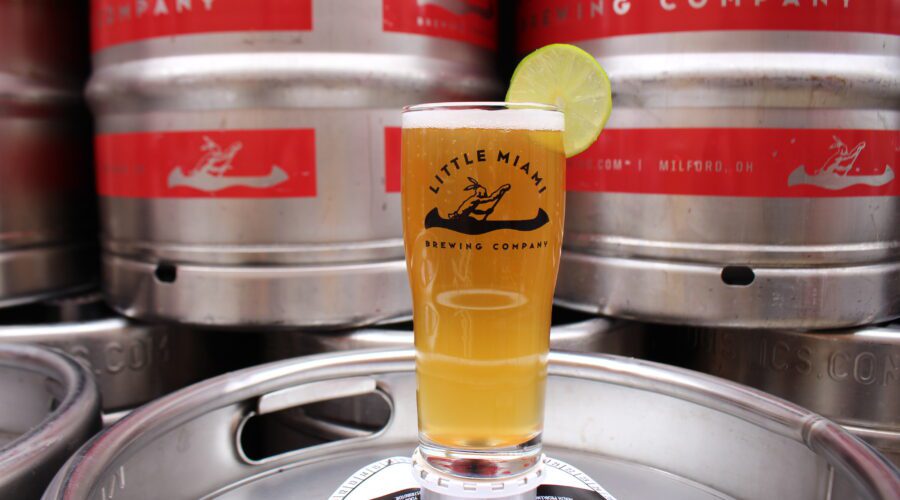 Glass of amber beer from Little Miami Brewing Company resting on a stainless steel beer keg.