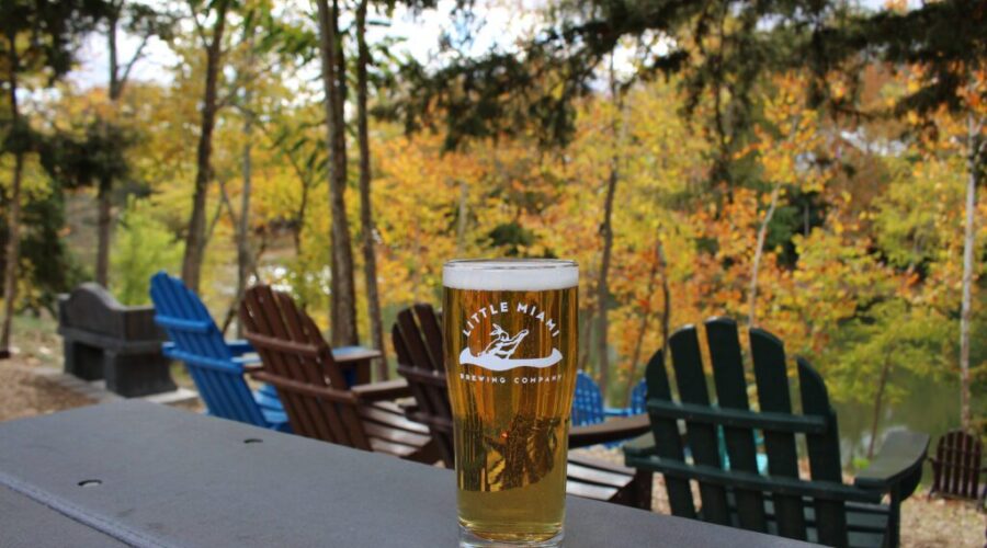 LMBC beer glass on patio with chairs and trees overlooking the Little Miami River in Milford, near Cincinnati.