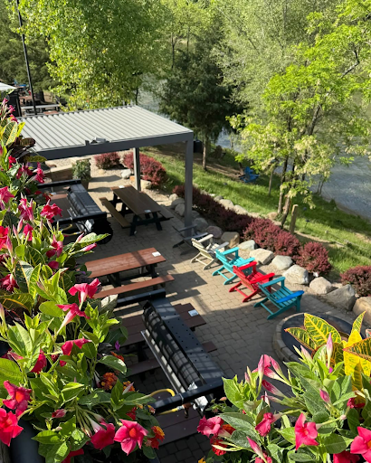 Riverside patio at LMBC in Milford with tables, chairs, and scenic view of the Little Miami River.