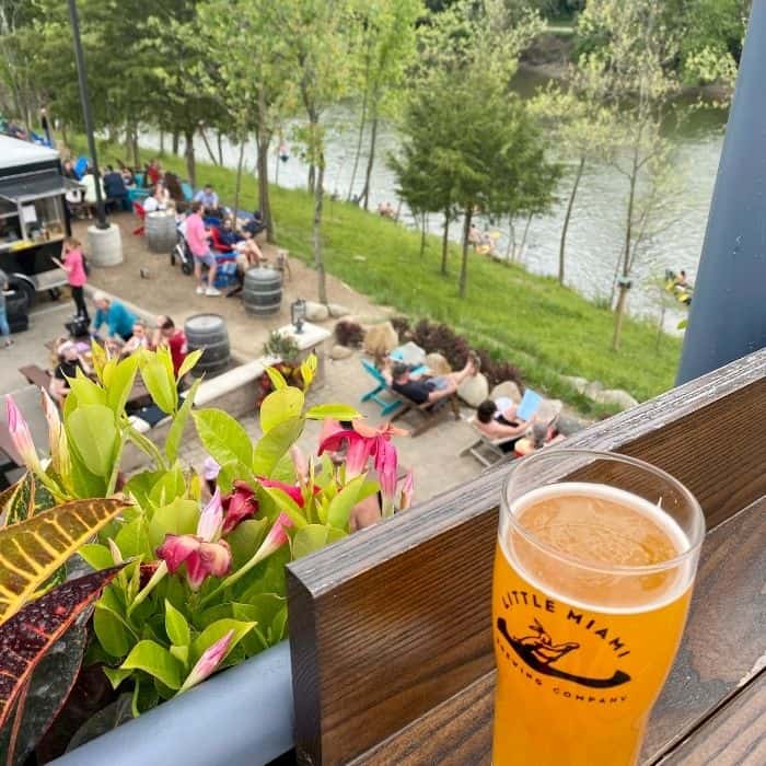 A glass of orange juice Imagine a sunny day by a river. You're on a wooden deck, feeling the warm breeze on your face. The river is sparkling below, with people enjoying the outdoors. There are colorful plants and flowers around you. You're holding a glass of orange juice, and you can hear the laughter and chatter of people enjoying themselves. This might be the perfect place to plan your dream wedding, with the beautiful scenery and relaxed atmosphere.