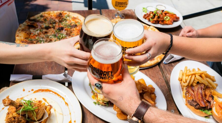 Friends enjoying a perfect party event with beer, pizza, and delicious food.