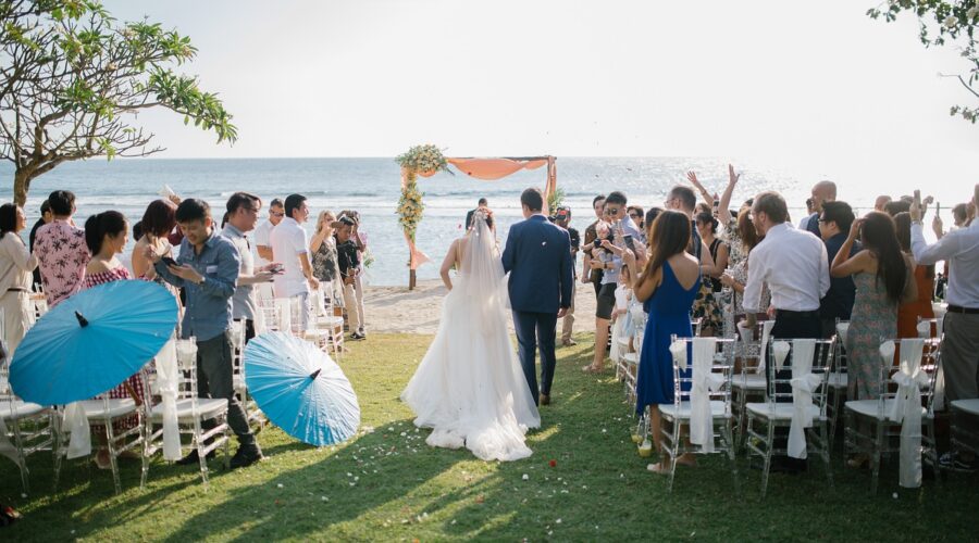 Outdoor beach wedding ceremony setup with guests facing the ocean, ideal for a coastal-themed wedding celebration.