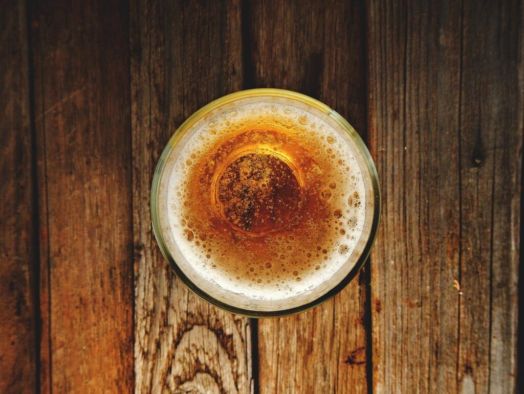 Flat lay shot of a glass of rich beer with a foam head on top.
